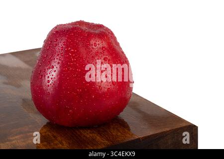 Fresh water sprinkled red apple on oak wood, isolated on white background. Nutrition and Health care concept Stock Photo
