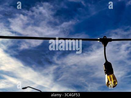 Outdoor light bulb hanging outside a restaurant. Stock Photo