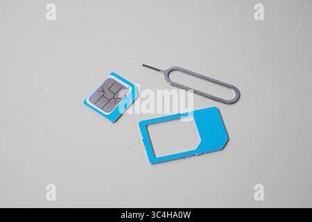 Close up macro of SIM card and SIM tray ejector tool. Perfect for tech blogs, smartphone repair articles, mobile tutorials, or telecommunications-rela Stock Photo