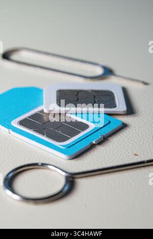 Close up macro of SIM card and SIM tray ejector tool. Perfect for tech blogs, smartphone repair articles, mobile tutorials, or telecommunications-rela Stock Photo