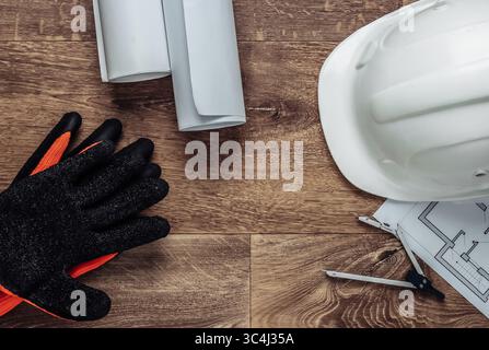 Creative layout of architects with roll drawings, architectural project plan, construction helmet and tools on floor, workspace. Top view. Flat lay Stock Photo