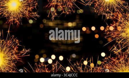 Sparkling border of glowing sparklers against a bokeh blurred backdrop of lights at night. Copy space Stock Photo