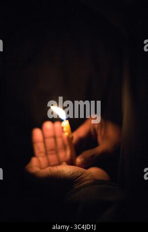 A person is carefully holding a lit lighter in their hand, Stock Photo