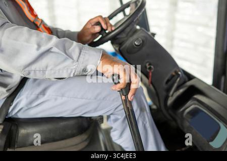 Worker operator controls a forklift inside a warehouse. Storage, inventory, industry, and logistics Stock Photo