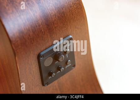 Closeup photo of the pickup of a brown wooden mahogany western guitar Stock Photo
