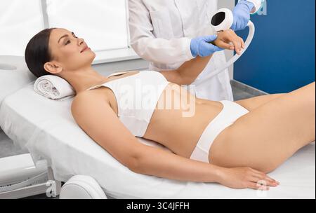 Removal of brown spots, freckles and rosacea on hands of female patient at cosmetology using machine with intense pulsed light IPL technology Stock Photo