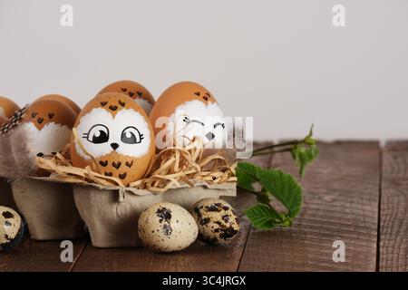 Funny owl family. Hand drawn owl Easter eggs, quail eggs and bird feathers. Space for your text. Stock Photo