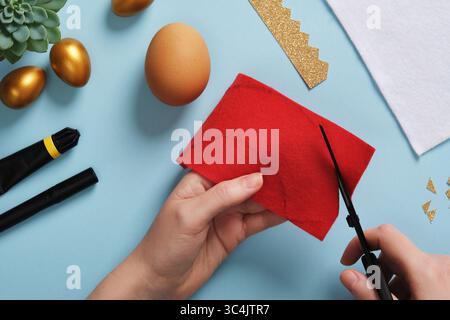 DIY Easter Egg King. Step-by-step instructions. Step 3. From the red felt, cut out a half circle for the king's mantle. Stock Photo