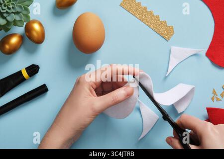 DIY Easter Egg King. Step-by-step instructions. Step 4. From white felt or fur, cut a semi-circular strip, the smaller part of it should match the sma Stock Photo
