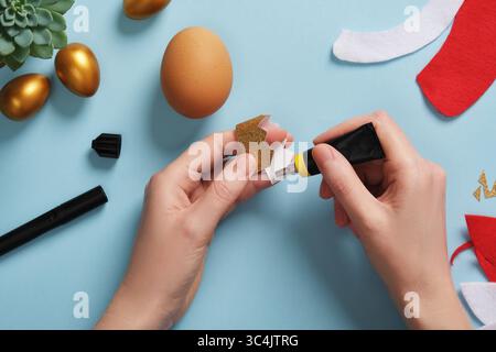 DIY Easter Egg King. Step-by-step instructions. Step 5. Glue the golden crown together using double-sided tape or glue. Stock Photo