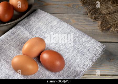 A vibrant display of multicolored chicken eggs rests on a rustic wooden table, showcasing nature's beauty and diversity. Ideal for themes of ecology, Stock Photo