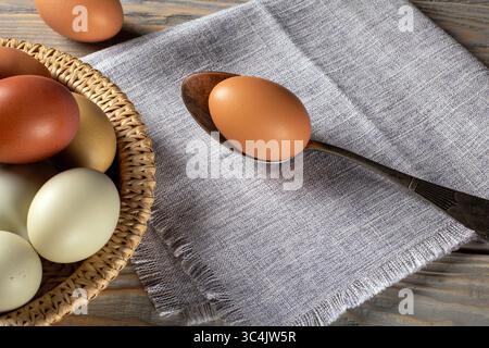 A vibrant array of eco-friendly chicken eggs in various colors, resting elegantly on a rustic wooden surface. Perfect for highlighting farm-fresh prod Stock Photo