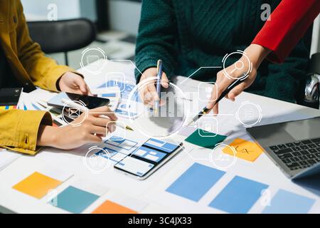 Close up view of UI developer team brainstorming on their project with laptop, smartphone and digital tablet. Creative digital development agency. Stock Photo