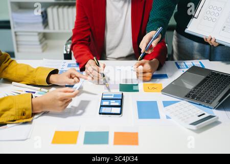Close up view of UI developer team brainstorming on their project with laptop, smartphone and digital tablet. Creative digital development agency. Stock Photo
