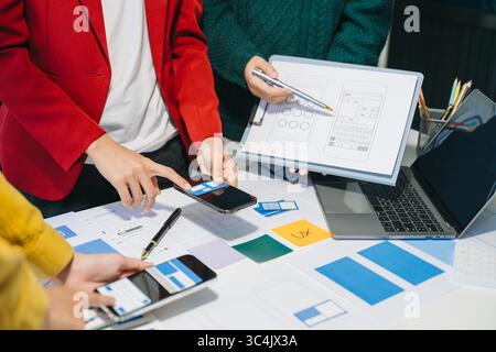 UX developer and ui designer brainstorming about mobile app interface wireframe design with customer breif and color code at modern office. Stock Photo