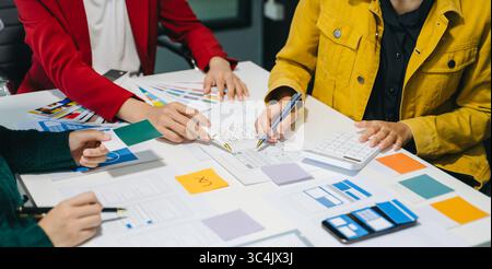 UX developer and ui designer brainstorming about mobile app interface wireframe design with customer breif and color code at modern office. Stock Photo