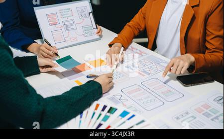 Close up view of UI developer team brainstorming on their project with laptop, smartphone and digital tablet. Creative digital development agency. Stock Photo