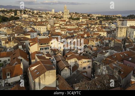 Aerial view of sun-kissed terracotta roofs sprawling across the ancient city, punctuated by the towering bell tower of the Cathedral of Saint Domnius, Split, Split-Dalmatia County, Croatia. Stock Photo