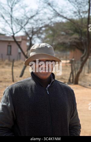 portrait of happy overweight single young man african woman , Botswana rural area, outdoors in the yard, house in the background Stock Photo