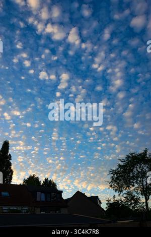 Beautiful Sky with Scattered Clouds Over a Neighborhood at Dusk Stock Photo