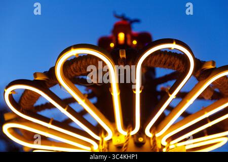 Illuminated Art Installation in Twilight featuring Neon Lights and Twisted Rope Design against a Deep Blue Sky Backdrop Stock Photo