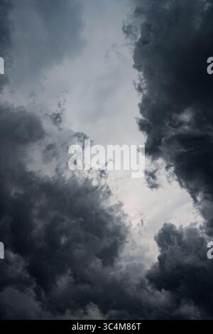 Vertical photo of dark gray storm clouds before rain. Storm, darkness, death. Perfect photo for nature, climate, weather, drama. Stock Photo