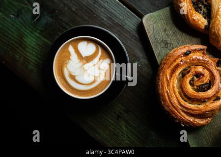 Cup of Cappuccino served with cinnamon on a rustic wooden table in a cozy coffee shop. Aesthetic cafe atmosphere, perfect for a relaxing break or brun Stock Photo
