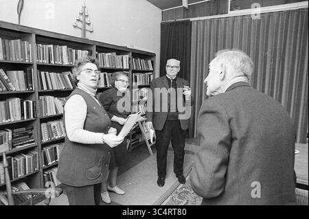 Rehearsal for the elderly, Theater, 06-01-1972 Whizgle News, Dutch Desk, The Netherlands, 1950-2000 A group of four people engage in a lively discussion in a cozy library setting, surrounded by shelves filled with books. Two women are animatedly speaking, while a man and another woman listen intently, creating a warm atmosphere of collaboration and conversation. Stock Photo