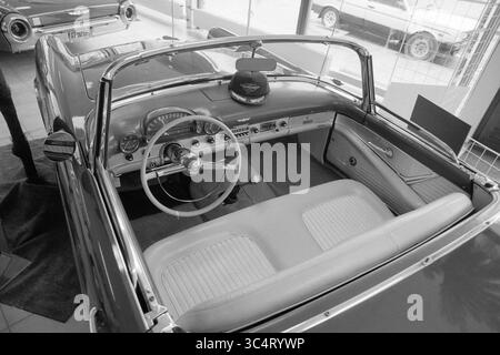 Detail of classic convertible Whizgle News, Dutch Desk, The Netherlands, 1950-2000 An elegant convertible car interior showcases a classic design, featuring a stylish steering wheel, plush seating, and vintage dashboard controls, all bathed in a timeless aesthetic. A hat rests on the passenger seat, hinting at adventures yet to come. Stock Photo