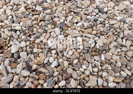 An arrangement of variously shaped and sized smooth river rocks in natural tones, creating a textured surface Stock Photo