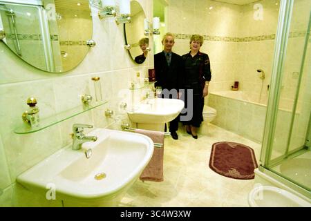 Furniture boulevard Cruquius, Cruquius, 16-03-1998 Whizgle News, Dutch Desk, The Netherlands, 1950-2000 A well-appointed bathroom featuring modern fixtures, elegant mirrors, and stylish decor. A couple stands together, showcasing their pride in the space, which includes a bathtub, shower, and twin sinks, all complemented by tasteful accents. Stock Photo