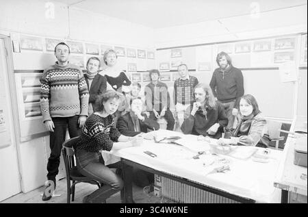 Group Perspeekt, Theater, 21-12-1981 Whizgle News, Dutch Desk, The Netherlands, 1950-2000 A diverse group of individuals gathers around a table in a cozy room, with some seated and others standing. They engage in conversation and share smiles, surrounded by framed photographs on the walls, creating a warm and collaborative atmosphere. Stock Photo