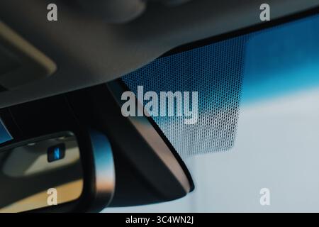 Detailed examination of a car's interior, highlighting the windshield area and mirror Stock Photo