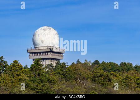 A radar dome from Austria’s air defense system stands atop a multi-story structure in a forest, used for monitoring and securing national airspace. Stock Photo