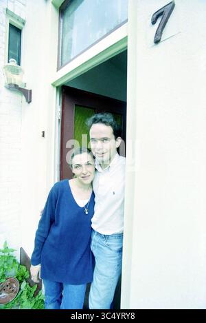 Family Rabbit, Haarlem, The Netherlands, 22-07-2001 Whizgle News, Dutch Desk, The Netherlands, 1950-2000 A man and woman stand together at the entrance of a home, smiling warmly as they pose by the doorway. The woman wears a cozy sweater, while the man is dressed casually in a collared shirt. The number 7 is visible next to the door. Stock Photo