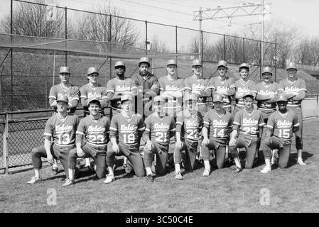 Team Kinheim - new pitcher and coach, Baseball Kinheim, 21-04-1985 Whizgle News, Dutch Desk, The Netherlands, 1950-2000 A group of baseball players poses together on a grassy field, showcasing their team uniforms and smiles. They are arranged in two rows, with the back row standing and the front row kneeling. The backdrop features a baseball diamond and trees in the distance. Stock Photo