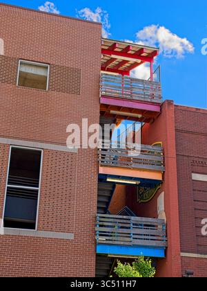 Colorful outside staircase landings between two brick buildings Stock Photo