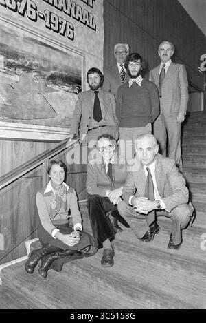 Dept. information town hall Velsen, Velsen Municipal Council, 27-10-1976 Whizgle News, Dutch Desk, The Netherlands, 1950-2000 A group of seven individuals poses on a staircase, featuring a mix of formal and casual attire. They are arranged in two tiers: four men stand at the back, while three, including one woman, are seated in front. The backdrop includes a large mural, hinting at a shared professional or academic connection. Stock Photo