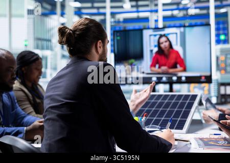 Solar panel factory management doing videocall with investors to showcase manufacturing strategies. Photovoltaics plant executives doing videoconference to present shareholders production growth data Stock Photo