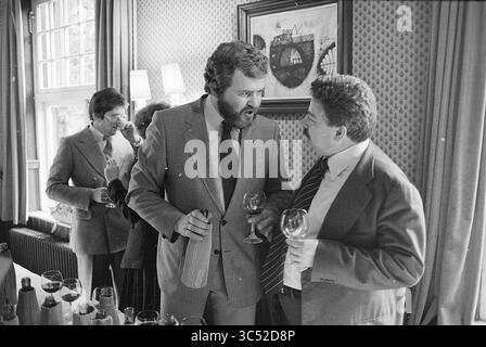 Wine tasting + presentation booklet in De Hoefslag Bilthoven, Wine, Bosch en Duin, Vossenlaan, 09-05-1978 Whizgle News, Dutch Desk, The Netherlands, 1950-2000 A group of well-dressed individuals engages in conversation at a social gathering, with drinks in hand. Two men animatedly discuss something of interest, while a third person appears in the background, also participating in the event. The setting features elegant decor, adding to the sophisticated atmosphere. Stock Photo
