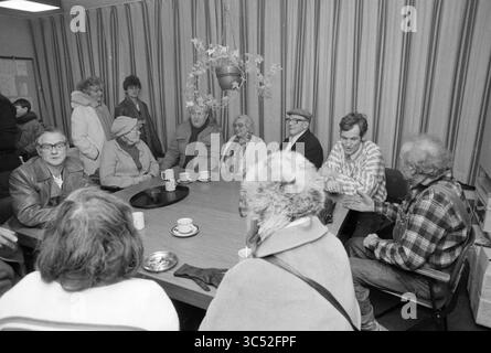 Some elderly people gathered around a table Whizgle News, Dutch Desk, The Netherlands, 1950-2000 A diverse group of individuals gathers around a large table in a cozy room, engaged in conversation. Various expressions and interactions reflect a sense of community, with some individuals sharing stories while others listen attentively. The setting suggests a relaxed atmosphere, possibly during a social event or meeting. Stock Photo