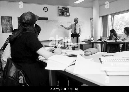 Ton Fikke, Employment Office, 21-05-1995 Whizgle News, Dutch Desk, The Netherlands, 1950-2000 A classroom setting where a teacher stands at the front, pointing at a whiteboard filled with notes. Students are seated at desks, engaged in taking notes and participating in the lesson. The atmosphere is focused and collaborative. Stock Photo