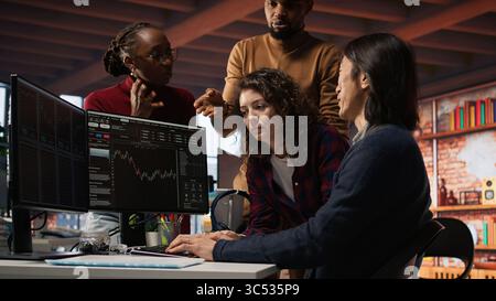 Startup team in office disappointed after watching stock exchange valuation decline because of market volatility. Upset venture workers analyzing charts, seeing stock valuation drop, camera A Stock Photo