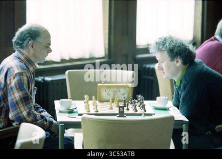 Chess: The White Horse Haarlem against The Owl, Haarlem, The Netherlands, 27-03-1998 Whizgle News, Dutch Desk, The Netherlands, 1950-2000 Two men engage in a focused game of chess at a table, with an ornate chess set and clocks in front of them. Each player contemplates their next move, surrounded by a cozy café atmosphere. Stock Photo