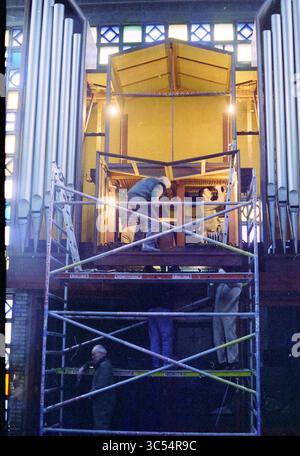 Demolishing the organ of the Petrus en Pauluskerk, 26-02-1995 Whizgle News, Dutch Desk, The Netherlands, 1950-2000 Construction workers are seen assembling scaffolding in front of a large, ornate organ within a beautifully designed hall. The intricate architecture is highlighted by colorful stained glass windows, casting a soft light over the scene. Two individuals are focused on their tasks, one working above and another below, emphasizing the collaboration required for this restoration project. Stock Photo