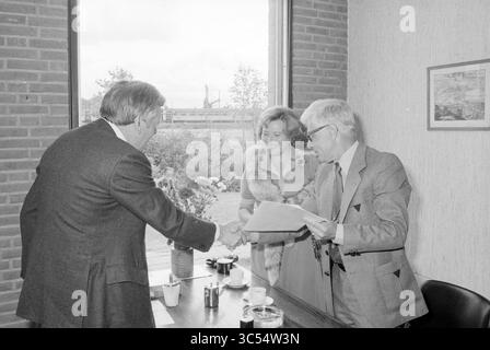 Anniversary Mr. Dubbe, Haarlems Dagblad, Haarlems Dagblad etc. and IJmuider Courant and Koeri, Anniversary, anniversaries, 31-08-1978 Whizgle News, Dutch Desk, The Netherlands, 1950-2000 A formal meeting in a well-lit setting, where two men are engaged in conversation while shaking hands, and a woman stands nearby, observing the exchange. A table with coffee cups and a document suggests a business or collaborative discussion taking place, with a window showing a glimpse of the outdoors. Stock Photo