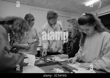 Start 'Technika 10', B'wijk, Beverwijk, The Netherlands, 09-02-1992 Whizgle News, Dutch Desk, The Netherlands, 1950-2000 A group of five individuals, including a teacher and students, engage in a hands-on art project, examining materials and collaborating around a crafting table. The atmosphere is focused and creative, with a variety of tools and papers scattered about. Stock Photo
