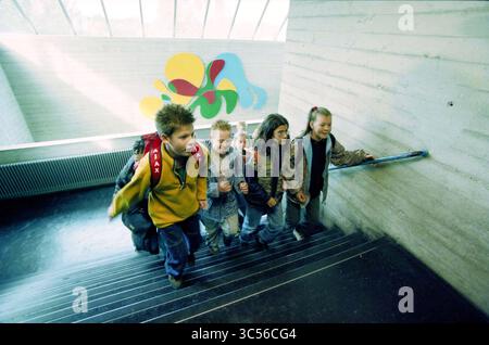 Students from the Molenwiek in the Linnaeus college Haarlem, Haarlem, The Netherlands, 30-09-1999 Whizgle News, Dutch Desk, The Netherlands, 1950-2000 A group of four children are ascending a staircase, smiling and engaged in conversation, while a colorful abstract mural decorates the wall nearby. One child carries a backpack, and they all appear to be enjoying their journey together. Stock Photo