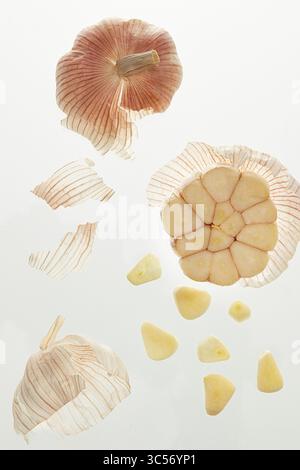 Close-up of Two Sliced Garlic Bulbs Revealing Intricate Internal Structure. Garlic on a white background, isolate, close-up. Stock Photo