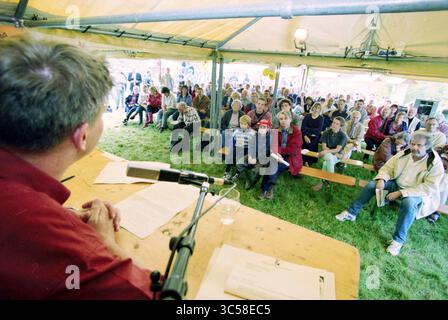 Presentation of the Milieudefensie report in a tent, Hoofddorp, The Netherlands, 19-09-1998 Whizgle News, Dutch Desk, The Netherlands, 1950-2000 A speaker addresses a large, captivated audience seated on benches under a tent. The crowd ranges from children to adults, all focused on the presentation taking place at the front. Stock Photo